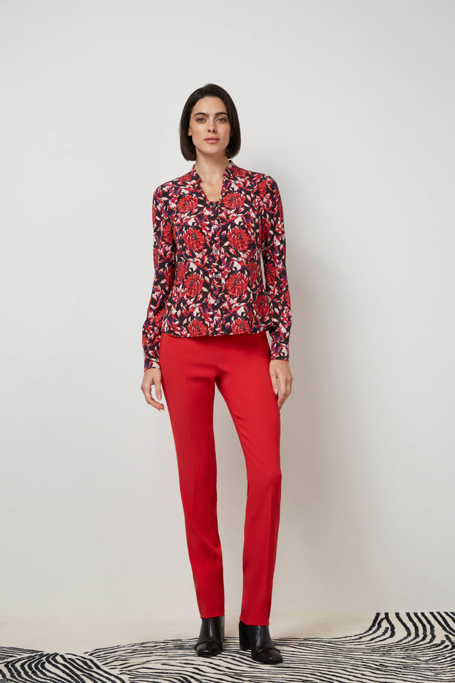 Front profile of a woman wearing a red 'Bard' blouse and red 'Cremisi' trousers