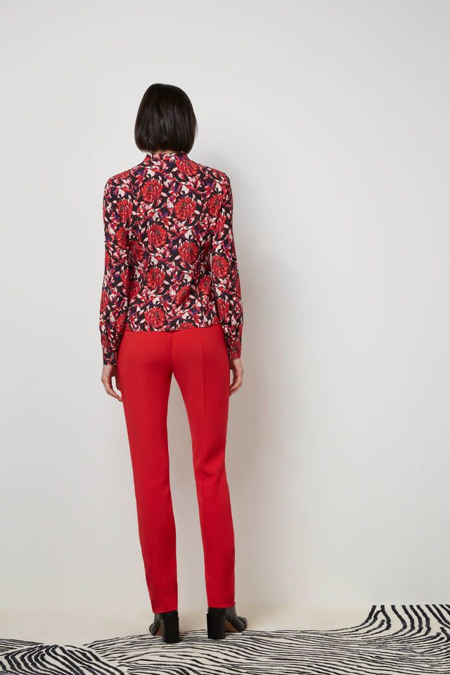 Back of a woman wearing a red 'Bard' blouse and red 'Cremisi' trousers