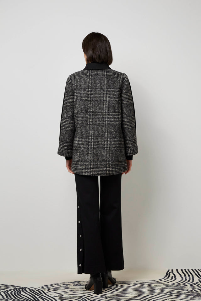 Back of a woman wearing the outside of a black 'Lara' knit coat